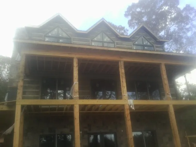 Dormers and porch framing on a large log home under construction — Roof Coating work by our crew in Wasco